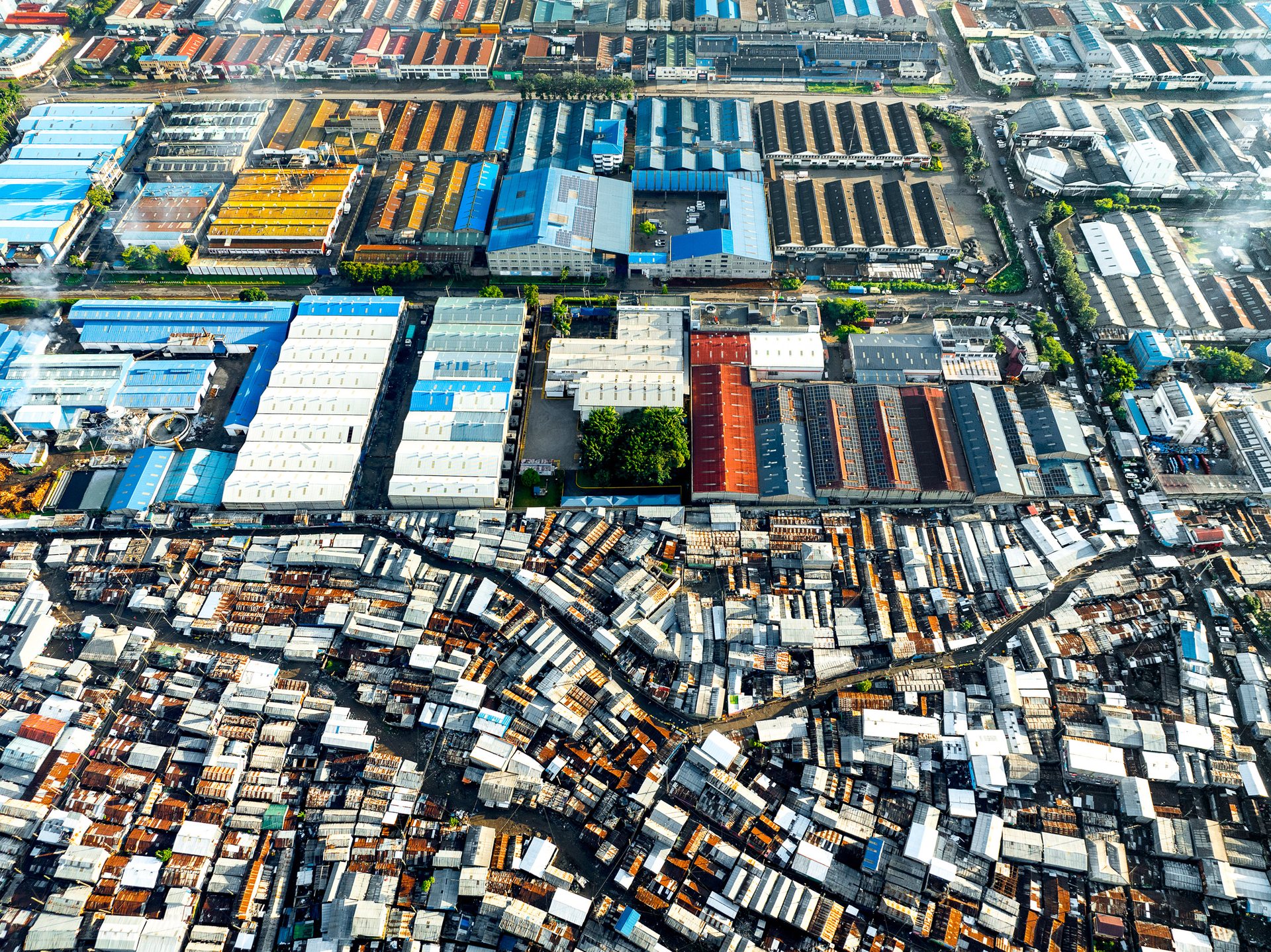 Overhead drone photo of Nairobi factory complexes bordering informal housing settlements.