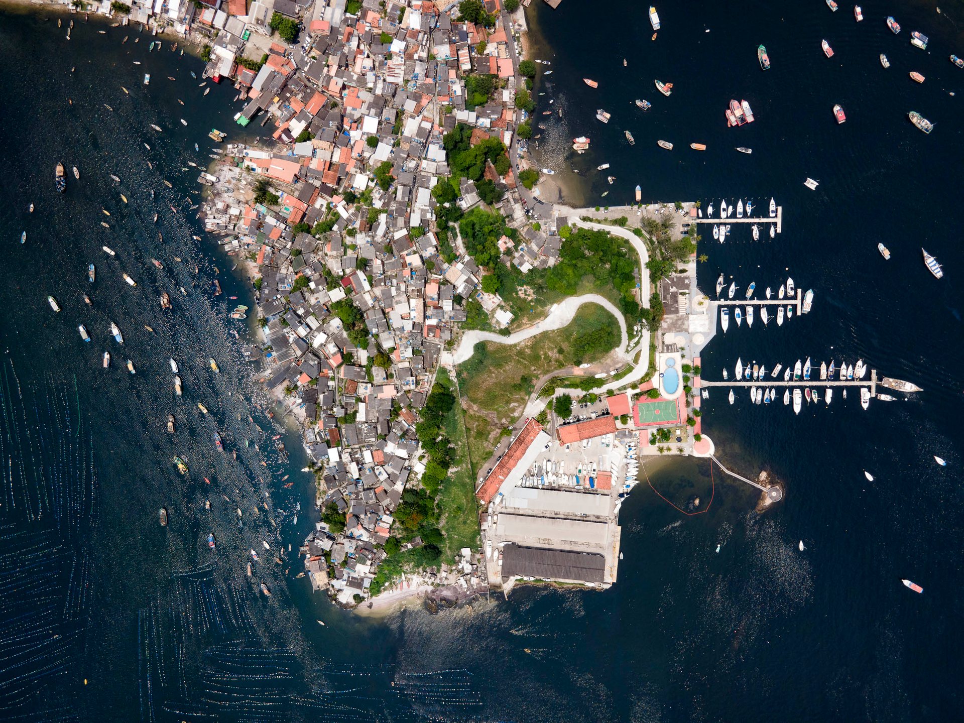 A top-down view of a yacht club next to a poor fishing village in Niteroi.
