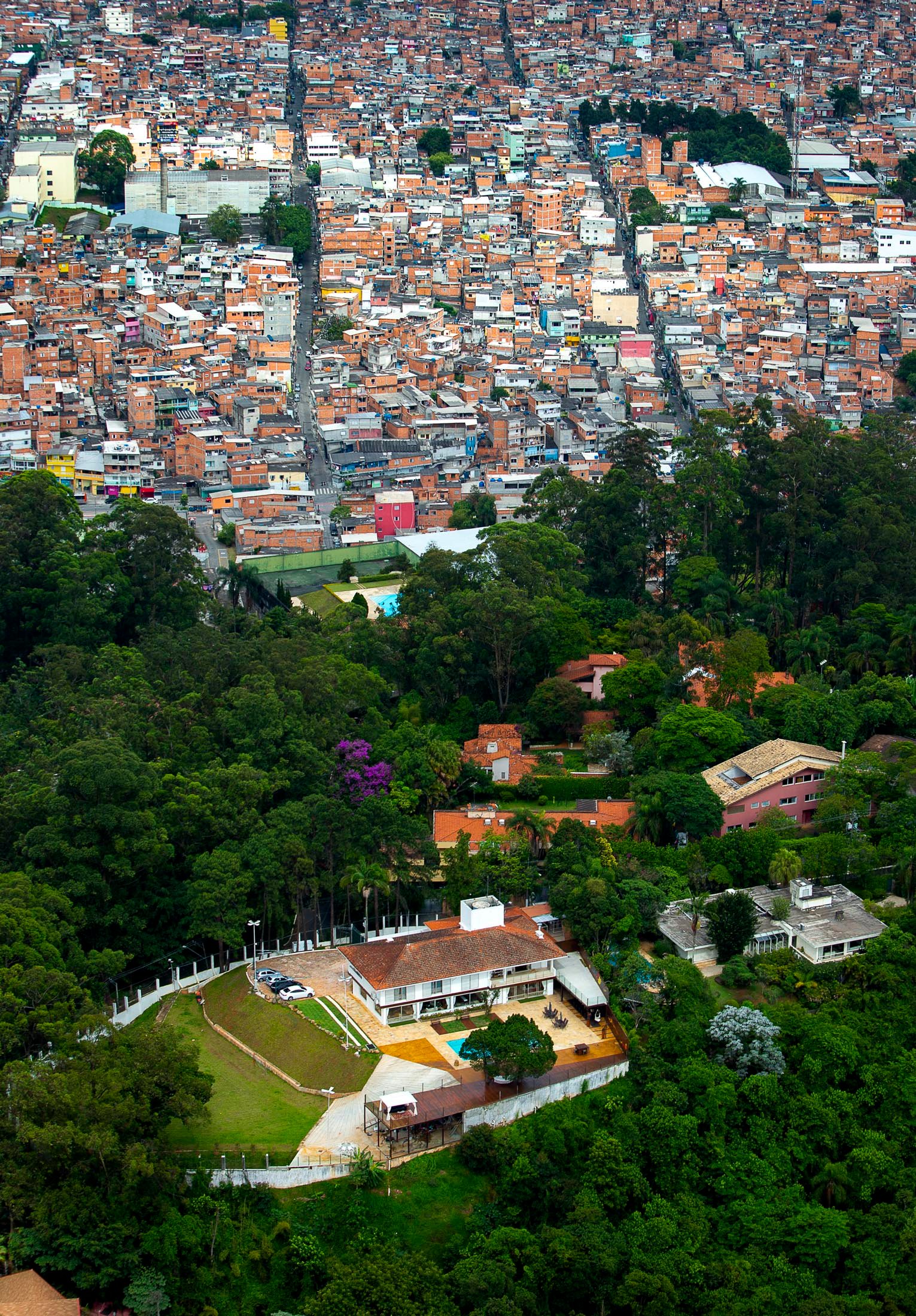Aerial view of Paraisópolis and Morumbi: two different urban logics separated by a thin strip of forest—informality versus planned wealth.